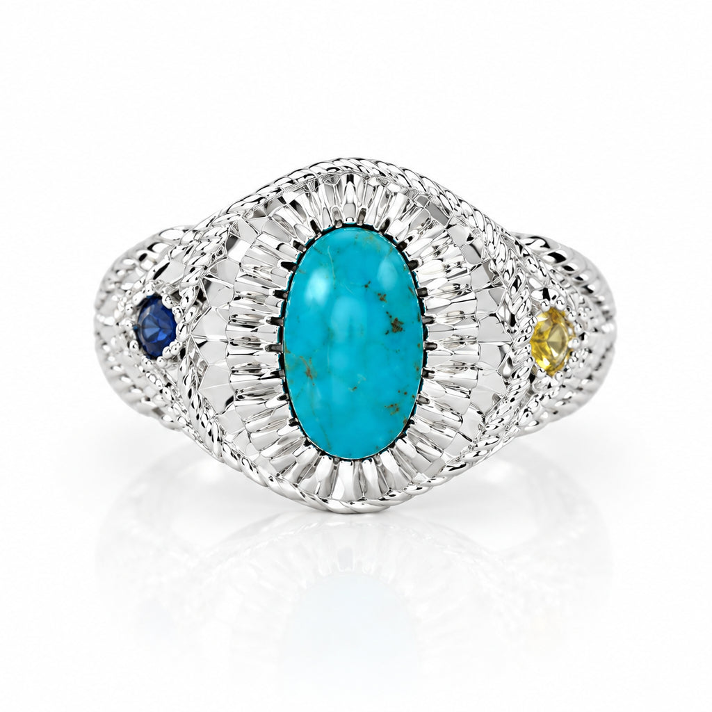 A vintage-style Art Deco ring featuring a central oval turquoise cabochon surrounded by a halo of small clear stones, accented with a small blue gemstone on one side and a tiny yellow gemstone on the other, set against a plain light gray background.